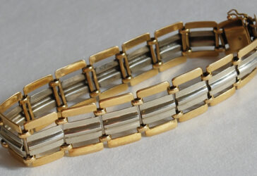 Un bracelet à maillons articulés or jaune et gris.