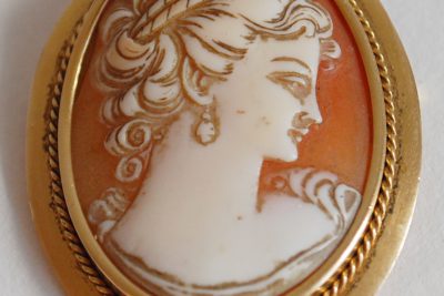 Une broche en or formant pendentif ornée d’un camée.