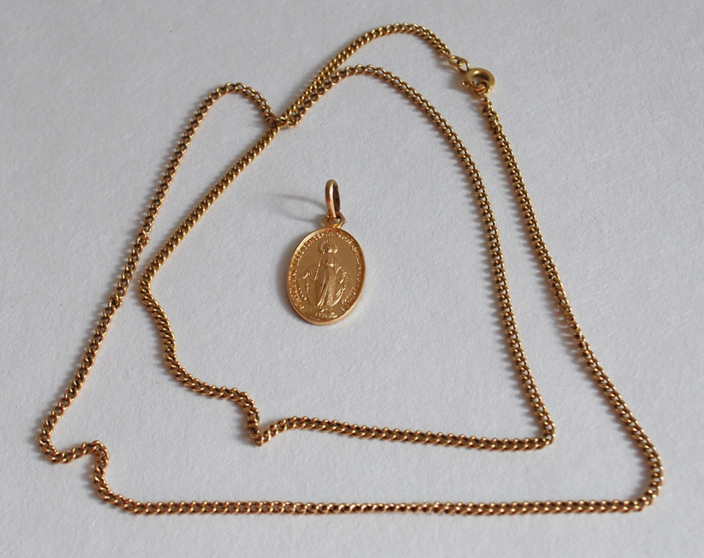 Chaîne en or. Poids brut : 9,9 g On y joint une médaille de la Vierge en métal doré.
