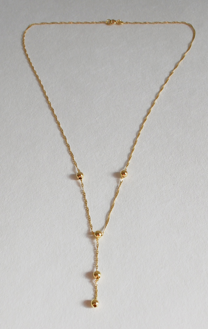 Collier en or à maillons très fins ornés de petites perles dorées. Poids brut : 2,4 g