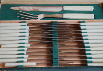 Partie de service à couteaux moderne comprenant 12 couteaux de table, 12 couteaux à fromage et un nécessaire à découper en résine imitant l'ivoire.