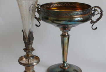 Ensemble comprenant une grande coupe sur piédouche à décor de frise de houx et guirlandes de perles et un grand vase en verre ciselé monté sur piédouche en métal argenté.