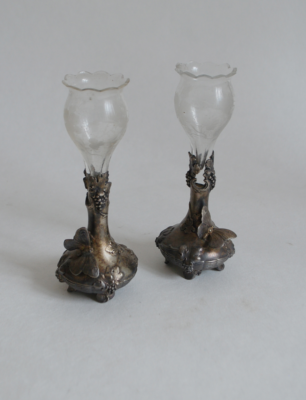 Paire de petits vases soliflores en métal argenté à décor Art Nouveau, le récipient en verre gravé.