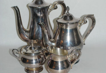 Partie de service à thé et café en métal argenté comprenant 2 théières, un sucrier, un pot à lait, posant sur piédouche, la prise en forme de graine.