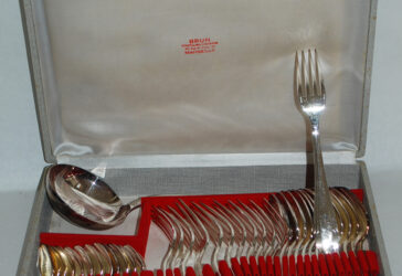BRUN Coutelier-Orfèvre Ménagère modèle Art Déco en métal argenté comprenant vingt-deux couverts de table, vingt-deux cuillères à dessert et une louche.