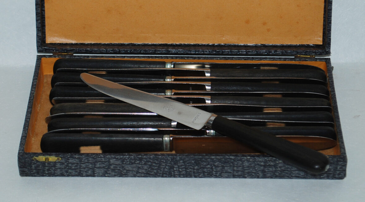 Lot de douze couteaux de table dépareillés, le manche en bois noirci, lames signées manufacture de Saint Etienne.