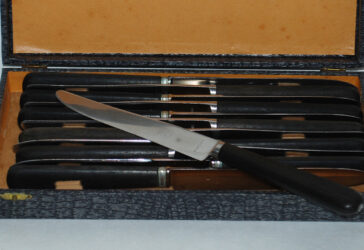 Lot de douze couteaux de table dépareillés, le manche en bois noirci, lames signées manufacture de Saint Etienne.