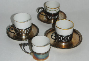 GALLIA Ensemble de trois tasses litron en porcelaine, la monture en métal argenté, avec deux soucoupes. On y joint une 4e non signée.