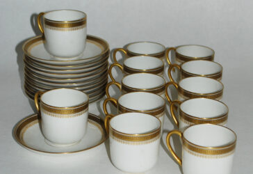 Partie de service à café en porcelaine à décor doré de frise de grecques et palmettes comprenant 12 tasses et sous tasses. Signé D&C France.