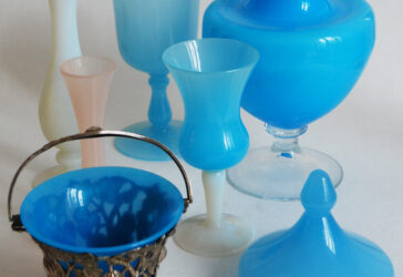 Ensemble en opaline comprenant deux petits vases soliflores, deux verres, un couvercle, une coupe à monture en métal et un grand vase sur piédouche .