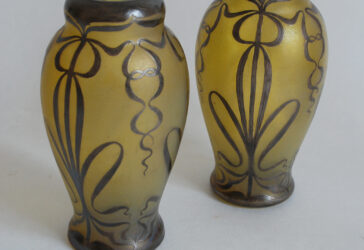 Paire de vases balustres en verre teinté jaune rehaussé d'un décor argenté de passementerie. XXe siècle.