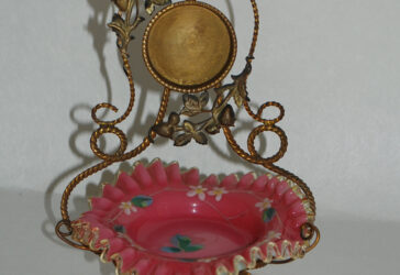 Baguier porte-montre en opaline rose à décor de fleurettes émaillées, la monture en bronze doré torsadé. Circa 1900.