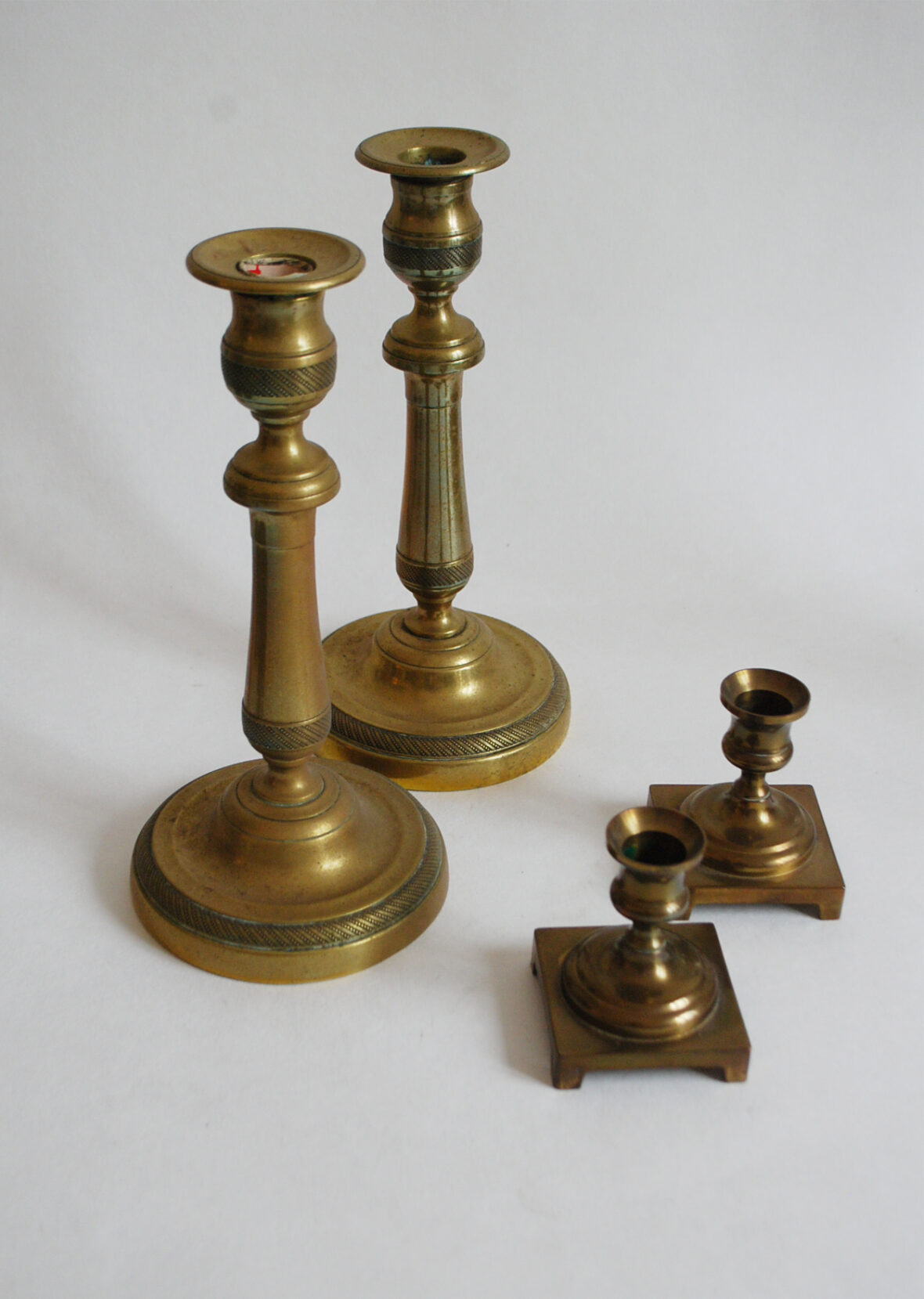 Ensemble comprenant deux paires de bougeoirs en bronze.