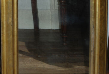 Miroir en bois doré à décor ciselé de feuillages et fleurettes.