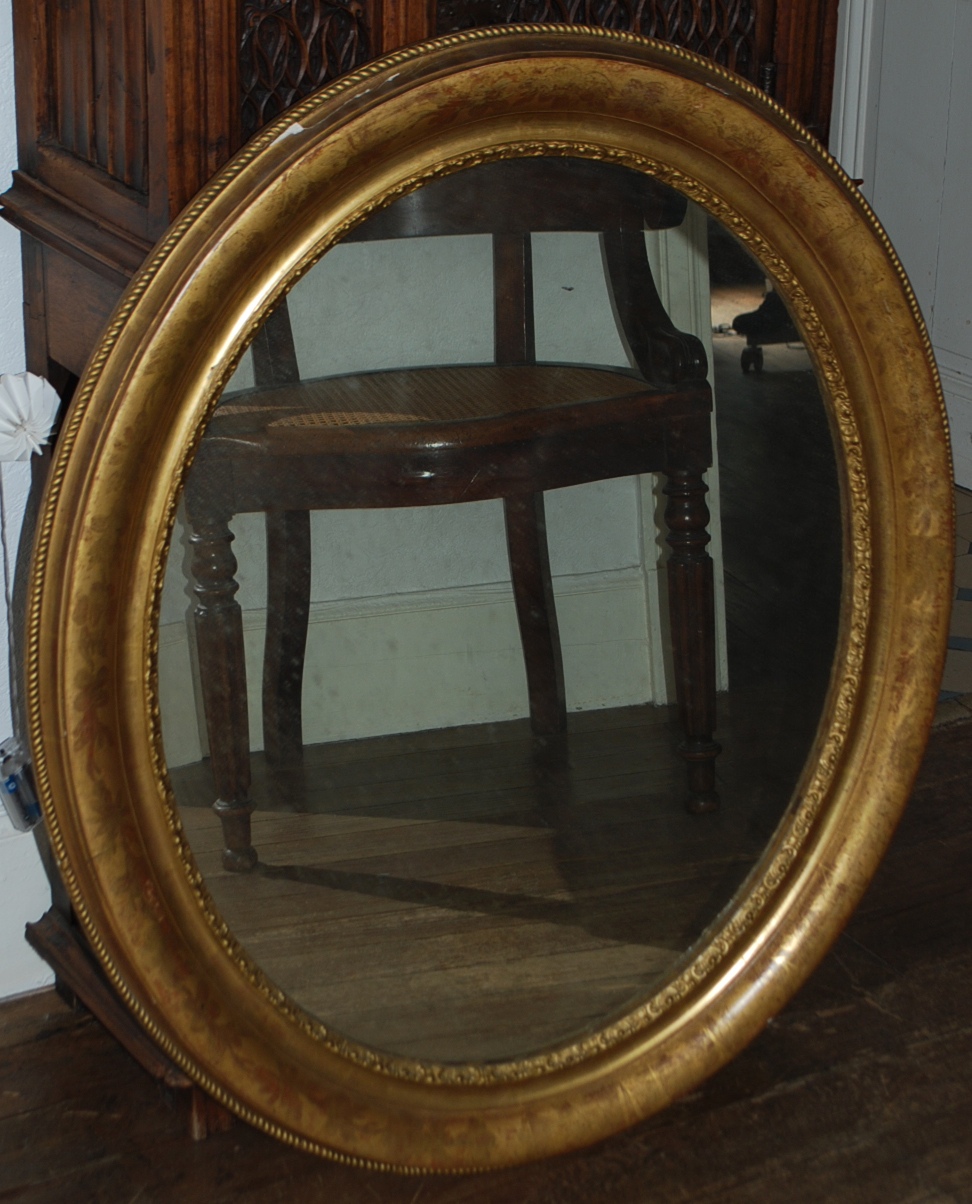 Grand miroir en bois doré et sculpté à décor de feuillages et torsades. Fin du XIXe siècle.