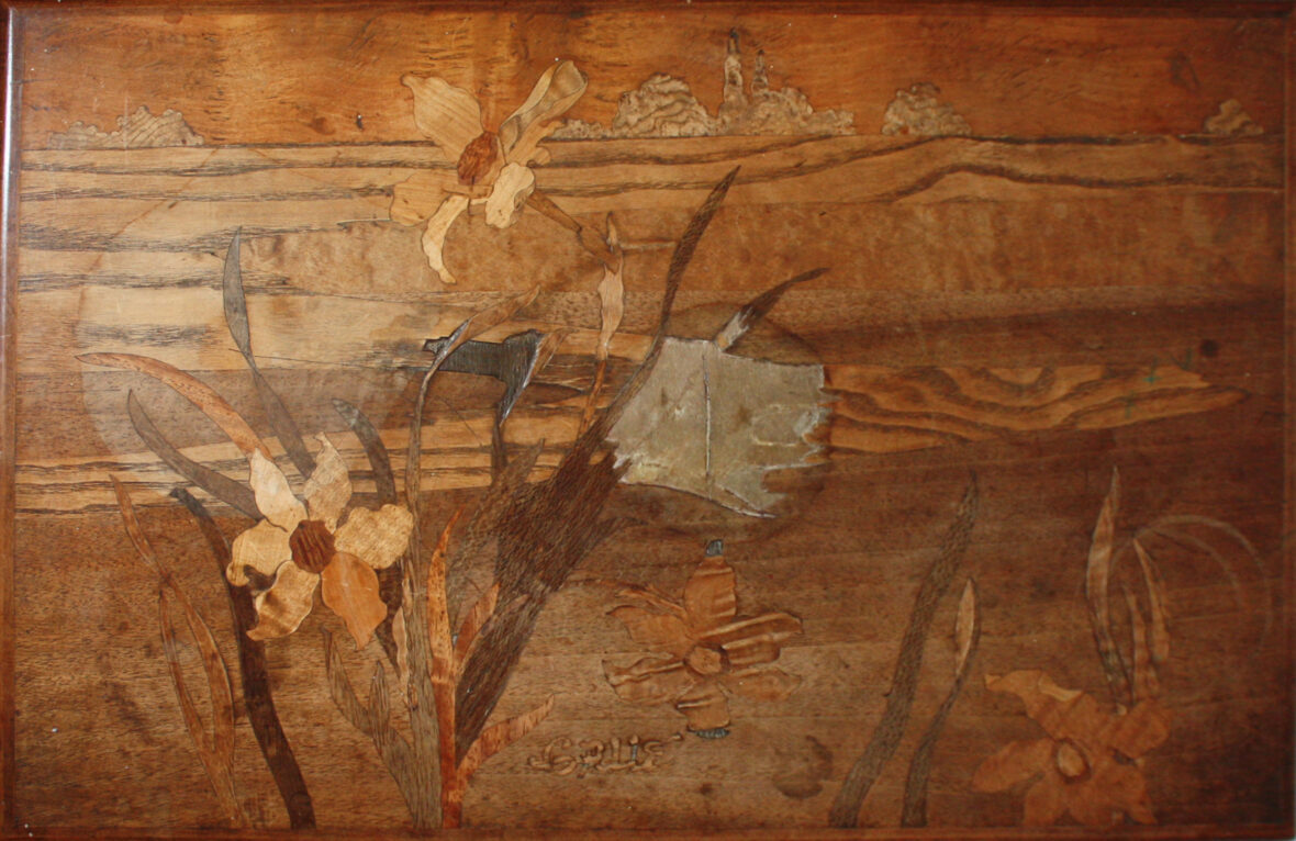 Émile GALLÉ (1846-1904) Suite de quatre tables gigogne en noyer mouluré et sculpté. Plateaux en décor de marqueterie figurant des iris. Signées.