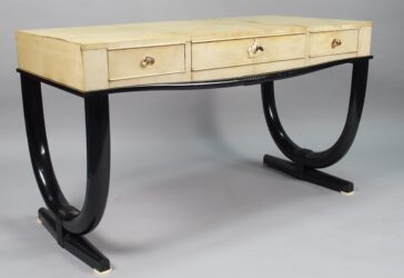 André ARBUS (1903-1969) Table bureau en parchemin et laque noire ouvrant à 3 tiroirs en ceinture (velin tâché par endroit et se soulevant légèrement au niveau des raccords).